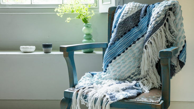 Image of a throw on a chair by a window